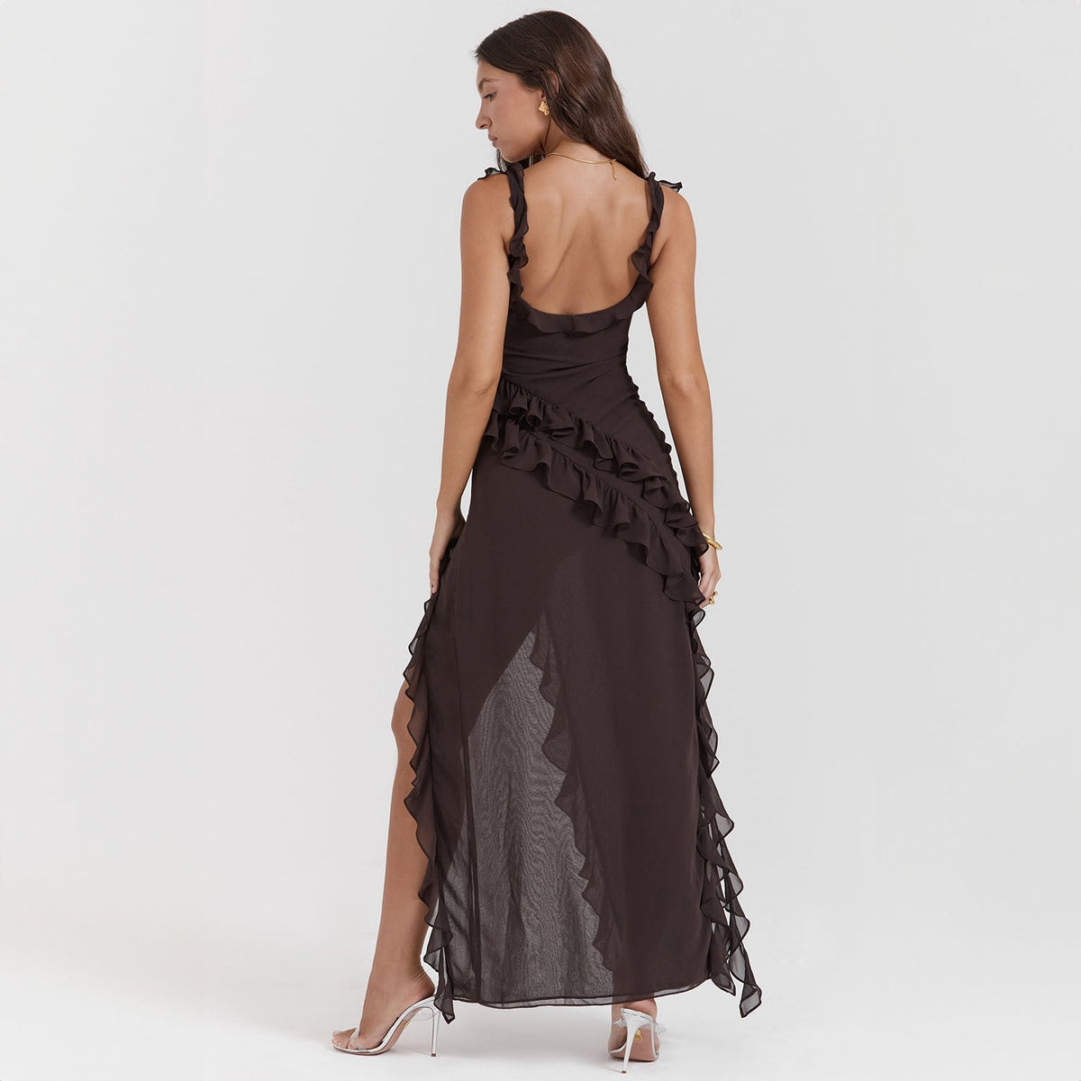 Abito lungo nero elegante con balze, schiena scoperta, indossato da donna. Perfetto per eventi serali e cerimonie. Moda femminile sofisticata.