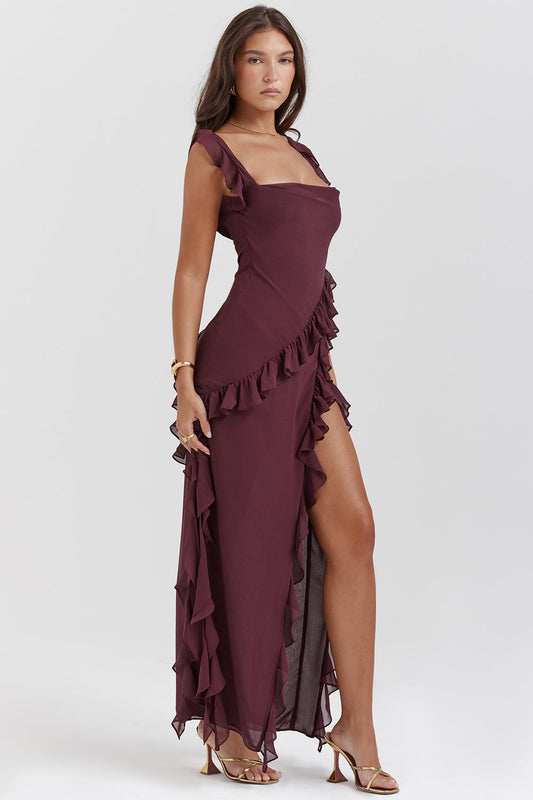 Abito lungo elegante bordeaux con volant, spacco laterale e spalline sottili. Perfetto per eventi serali e cerimonie. Moda donna sofisticata.