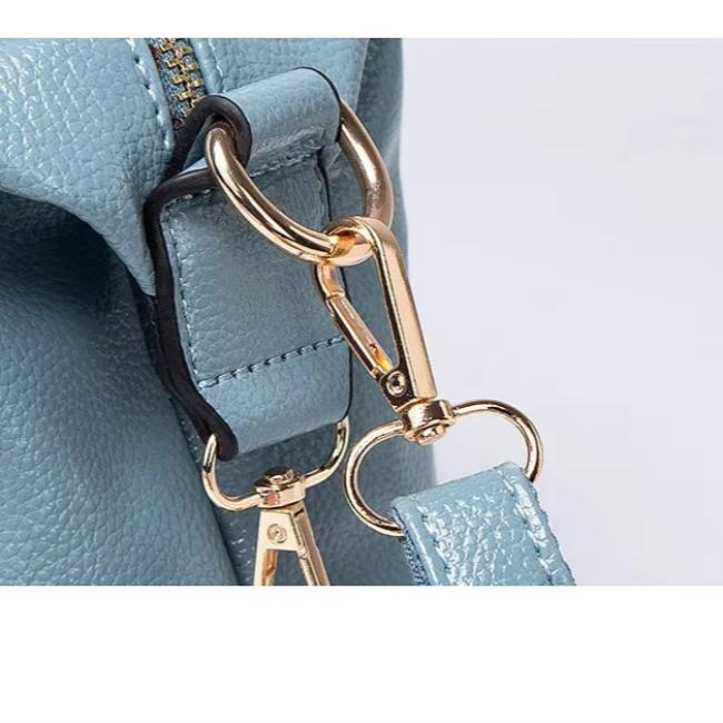 Borsa in pelle blu chiaro con dettagli in metallo dorato, moschettone robusto e cuciture precise. Accessorio moda elegante e di alta qualità.