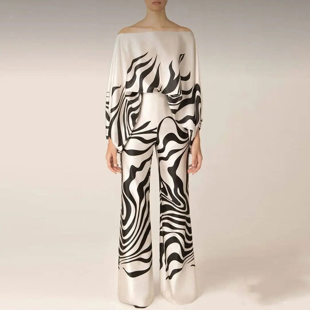 Abito elegante bianco e nero con motivo astratto, maniche lunghe e pantaloni larghi. Moda donna, stile sofisticato, tendenza 2023.