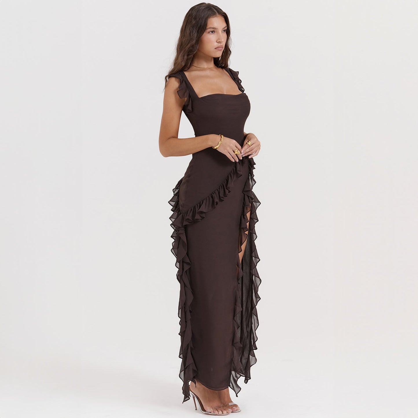 Abito lungo nero elegante con volant, senza maniche, indossato da una donna. Perfetto per eventi serali e cerimonie. Moda femminile sofisticata.