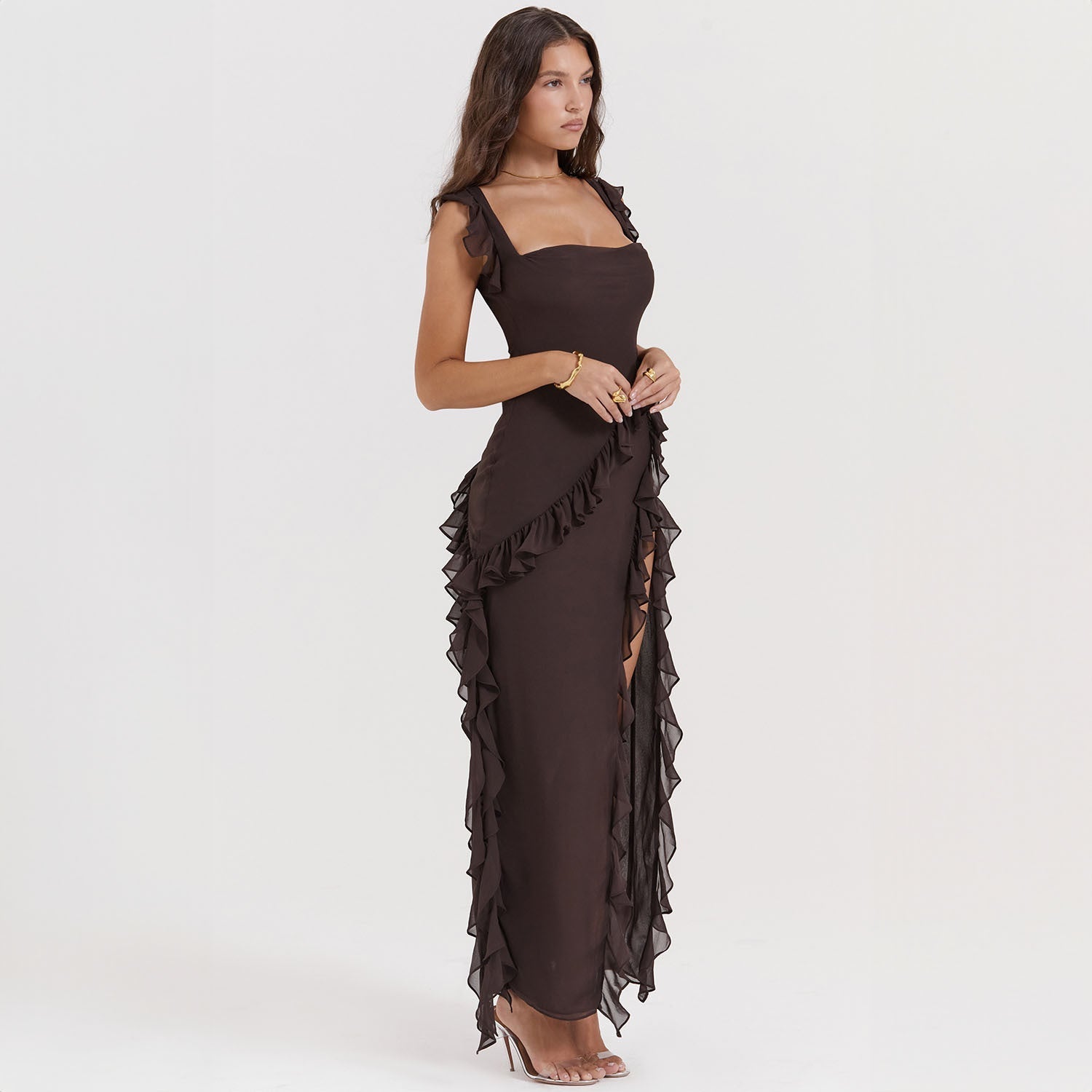 Abito lungo nero elegante con volant, senza maniche, indossato da una donna. Perfetto per eventi serali e cerimonie. Moda femminile sofisticata.