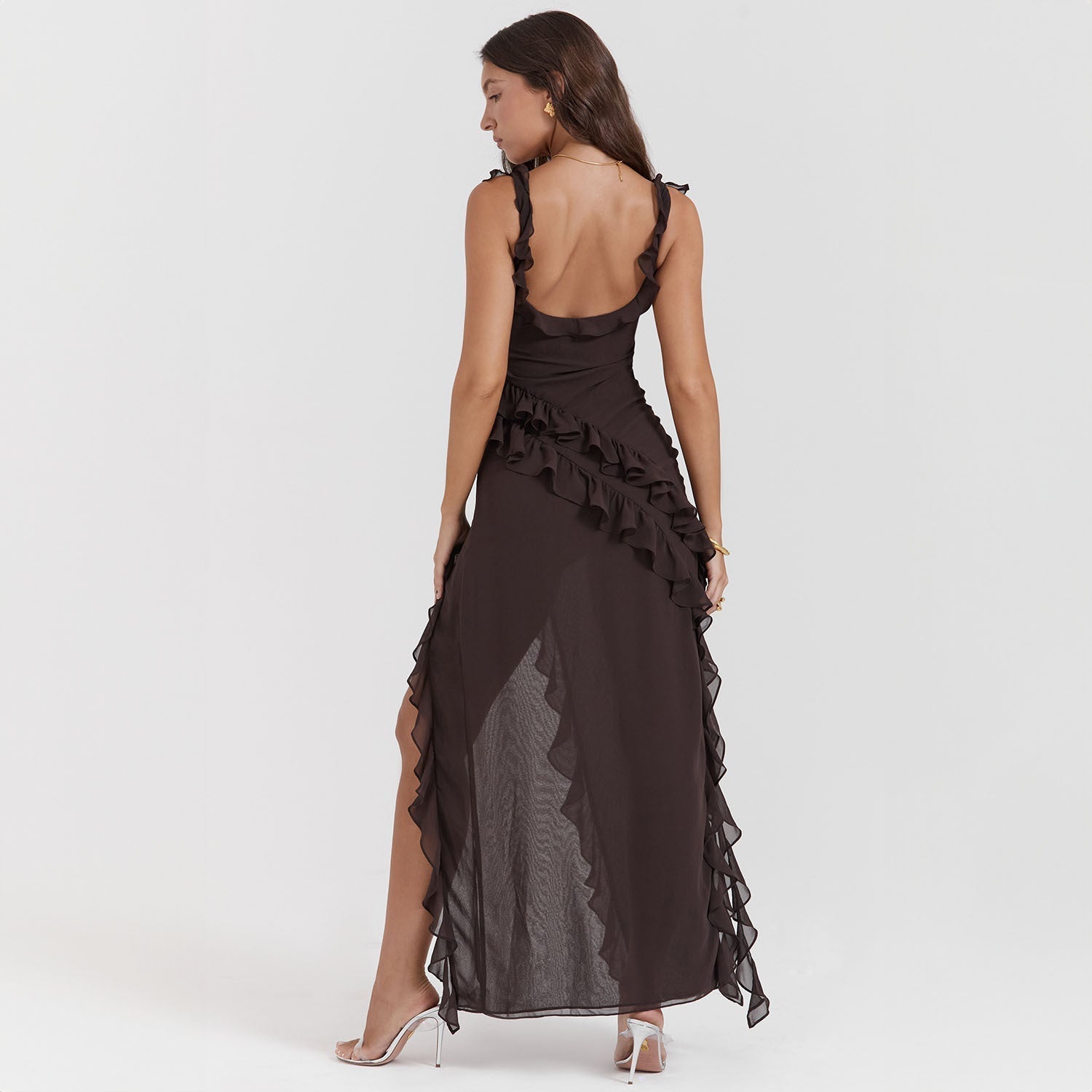 Abito lungo nero elegante con balze, schiena scoperta, indossato da donna. Perfetto per eventi serali e cerimonie. Moda femminile sofisticata.